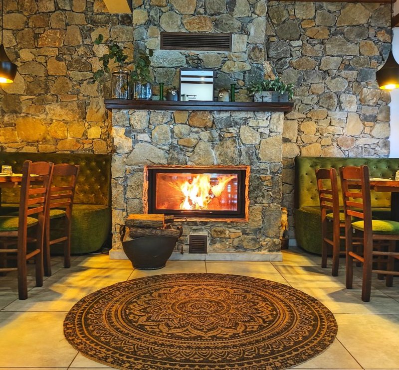 Stone fireplace and rustic dining room at Makris Restaurant in Moniatis