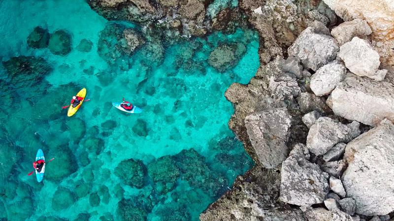 Kayaks beside a rocky coast